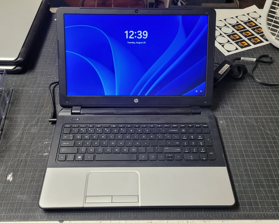Open HP 355 G2 15.6-inch refurbished laptop running Windows 11, showing its full-size keyboard, numeric keypad, touchpad, and display.